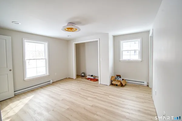an empty room with windows and closet
