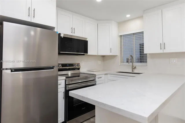 a kitchen with a refrigerator a stove and a cabinets