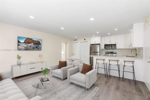a living room with furniture and kitchen view