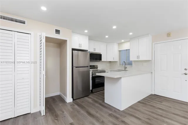 a kitchen with stainless steel appliances a refrigerator sink and microwave