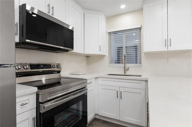 a kitchen with stainless steel appliances a stove a microwave and cabinets