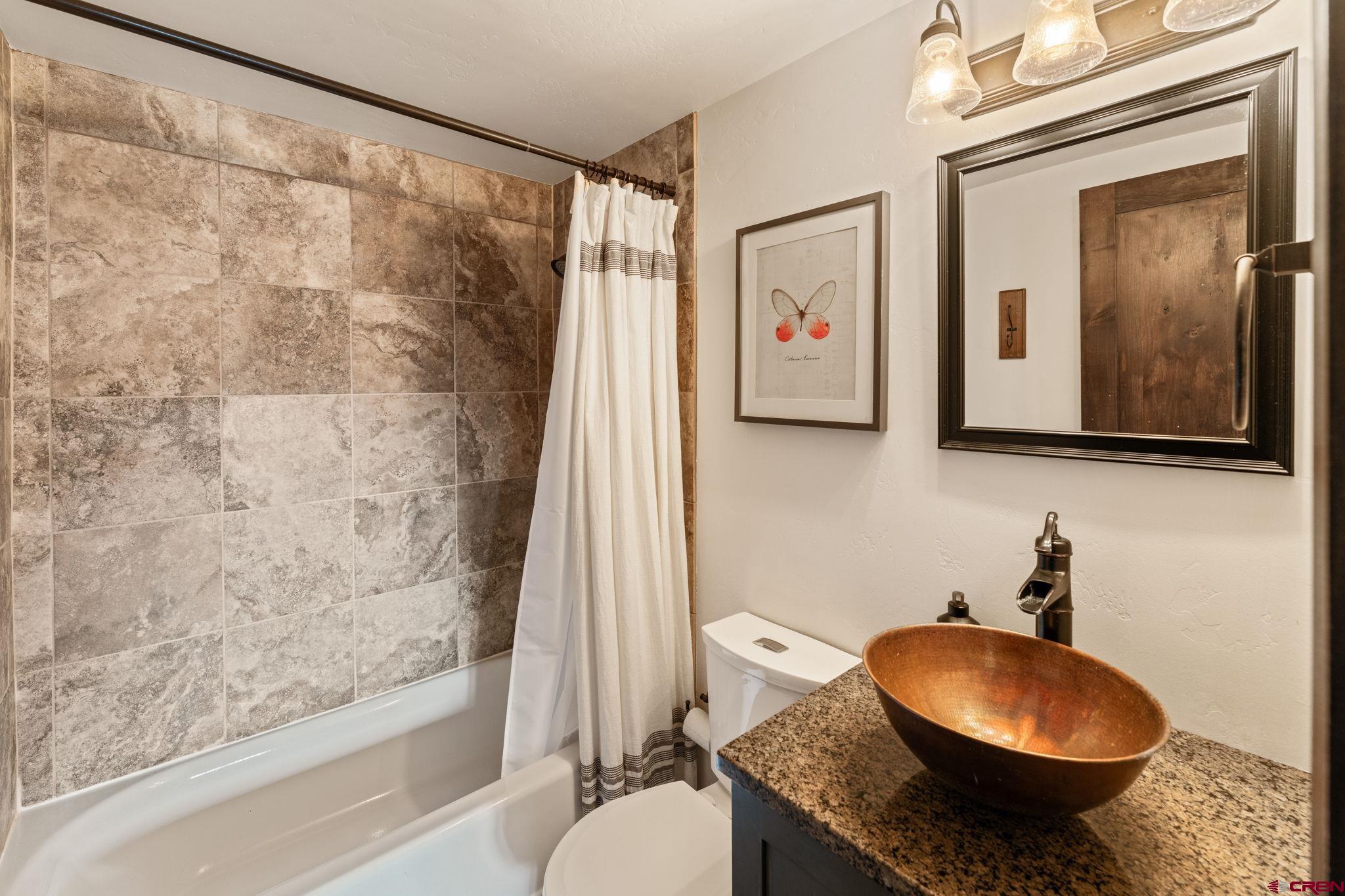 18 Crystal Road, Unit 5B Crested Butte, CO 81225 - Photo 14 of 25 a bathroom with a granite countertop toilet sink and mirror