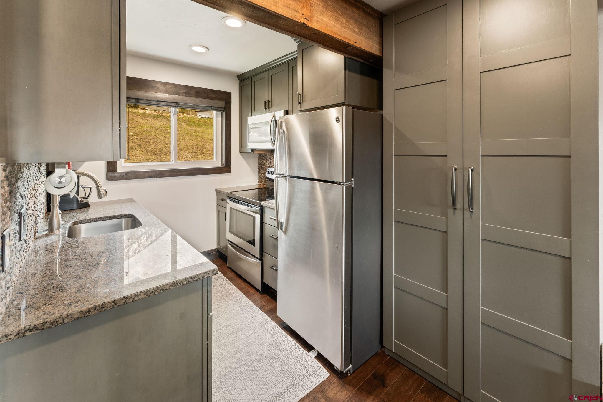 18 Crystal Road, Unit 5B Crested Butte, CO 81225 - Photo 6 of 25 a kitchen with stainless steel appliances granite countertop a refrigerator and a sink