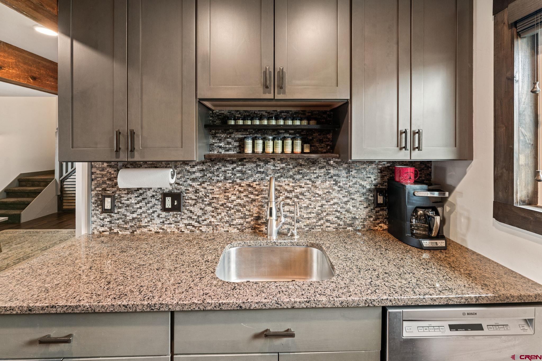18 Crystal Road, Unit 5B Crested Butte, CO 81225 - Photo 8 of 25 a kitchen with kitchen island granite countertop a sink a stove and cabinets