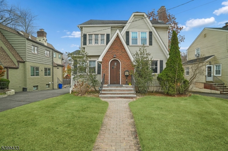 80 Locust Avenue Millburn, NJ 07041 - Photo 2 of 47 a view of a brick house with a big yard and large trees