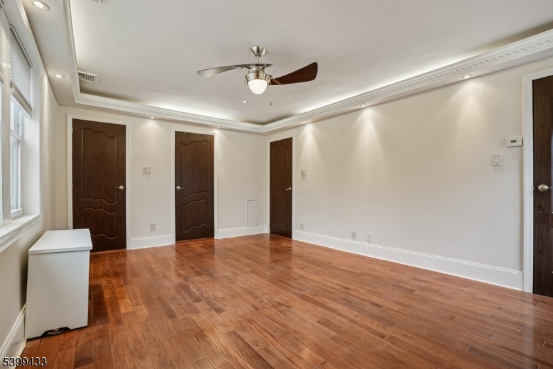 80 Locust Avenue Millburn, NJ 07041 - Photo 35 of 47 a view of an empty room with wooden floor and a ceiling fan