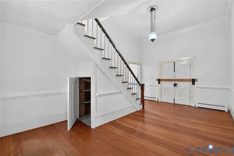 a view of a hallway with wooden floor and staircase