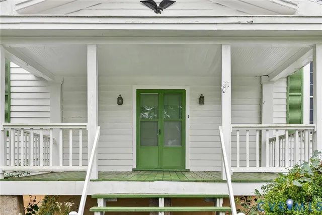 an empty room with wooden floor staircase and windows