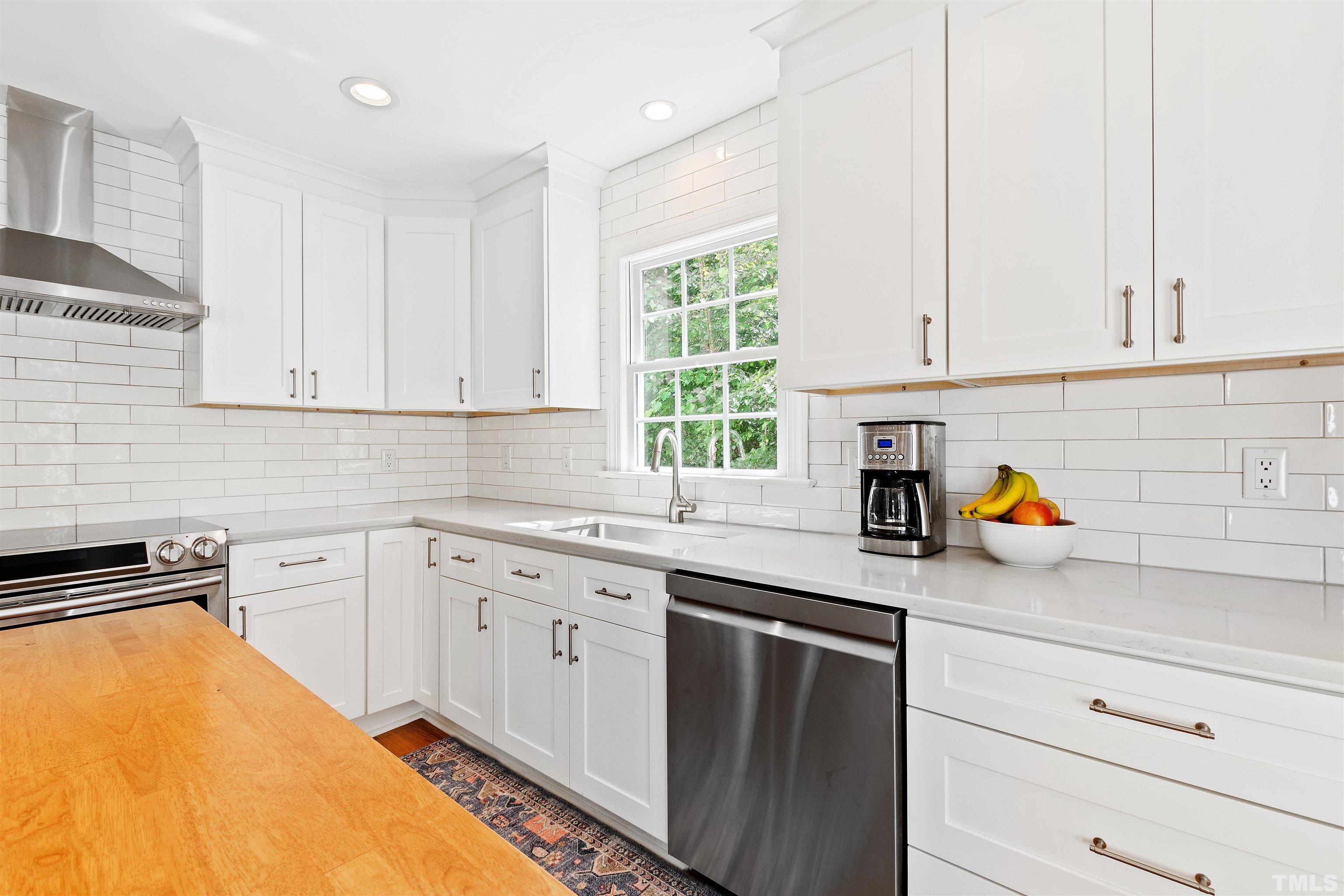 2960 Claremont Road Raleigh, NC 27608 - Photo 13 of 47 a kitchen with stainless steel appliances white cabinets sink and window