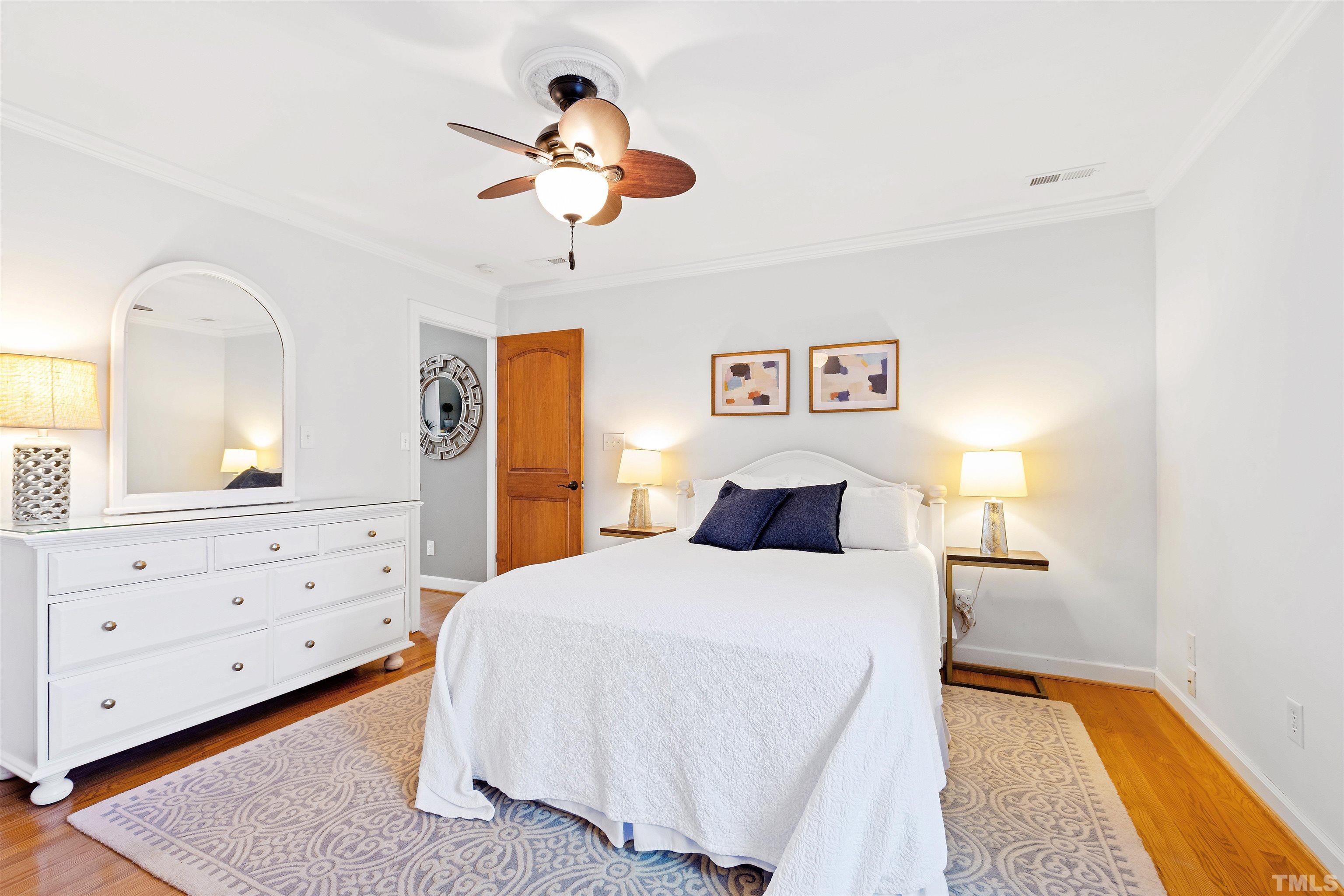 2960 Claremont Road Raleigh, NC 27608 - Photo 22 of 47 a bedroom with a large bed and a chandelier