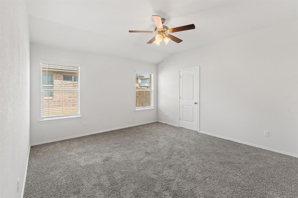 11101 Beckon Waco, TX 76708 - Photo 18 of 35 Spacious room featuring neutral carpeting, two windows with blinds, a ceiling fan with integrated lighting, and a paneled door