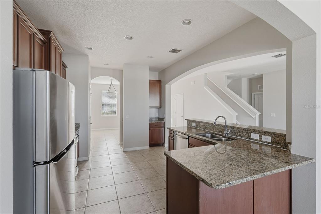 2318 Sebago Drive Lakeland, FL 33805 - Photo 11 of 54 a kitchen with stainless steel appliances granite countertop a sink and a refrigerator