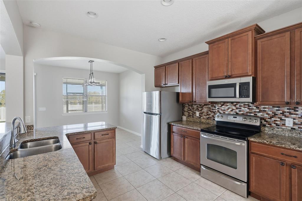 2318 Sebago Drive Lakeland, FL 33805 - Photo 12 of 54 a kitchen with stainless steel appliances granite countertop a stove microwave and sink