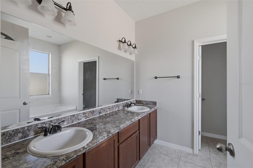 2318 Sebago Drive Lakeland, FL 33805 - Photo 20 of 54 a bathroom with a granite countertop sink and a mirror