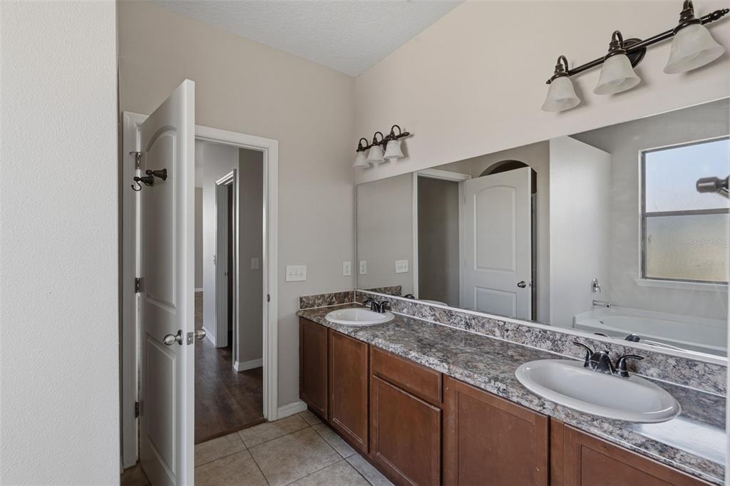 2318 Sebago Drive Lakeland, FL 33805 - Photo 22 of 54 a bathroom with a granite countertop sink and a mirror