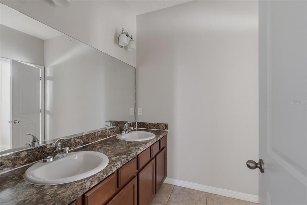 2318 Sebago Drive Lakeland, FL 33805 - Photo 26 of 54 a bathroom with a granite countertop sink and a mirror