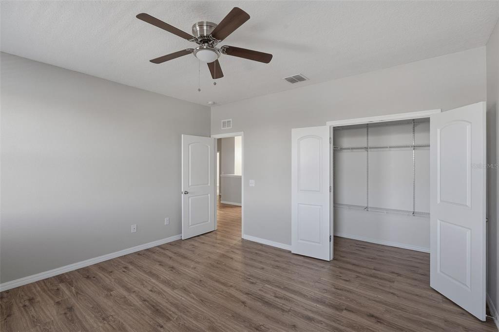 2318 Sebago Drive Lakeland, FL 33805 - Photo 29 of 54 an empty room with wooden floor and ceiling fan