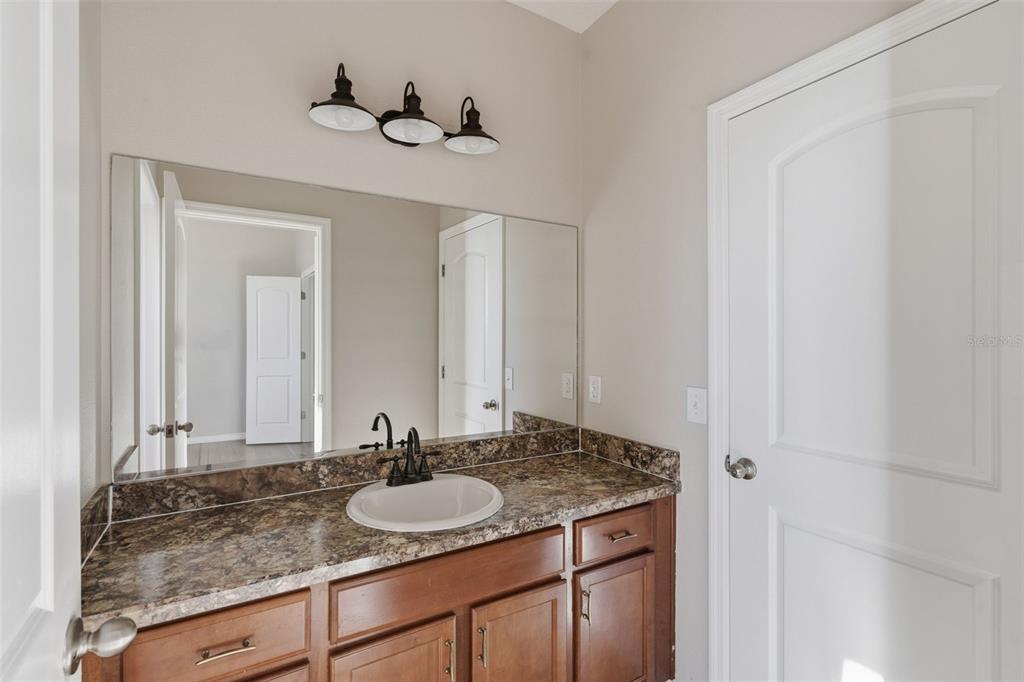 2318 Sebago Drive Lakeland, FL 33805 - Photo 37 of 54 a bathroom with a granite countertop sink and a mirror