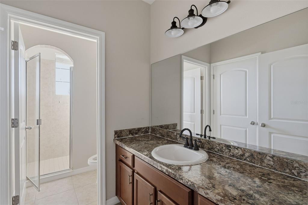2318 Sebago Drive Lakeland, FL 33805 - Photo 38 of 54 a bathroom with a granite countertop sink and a mirror