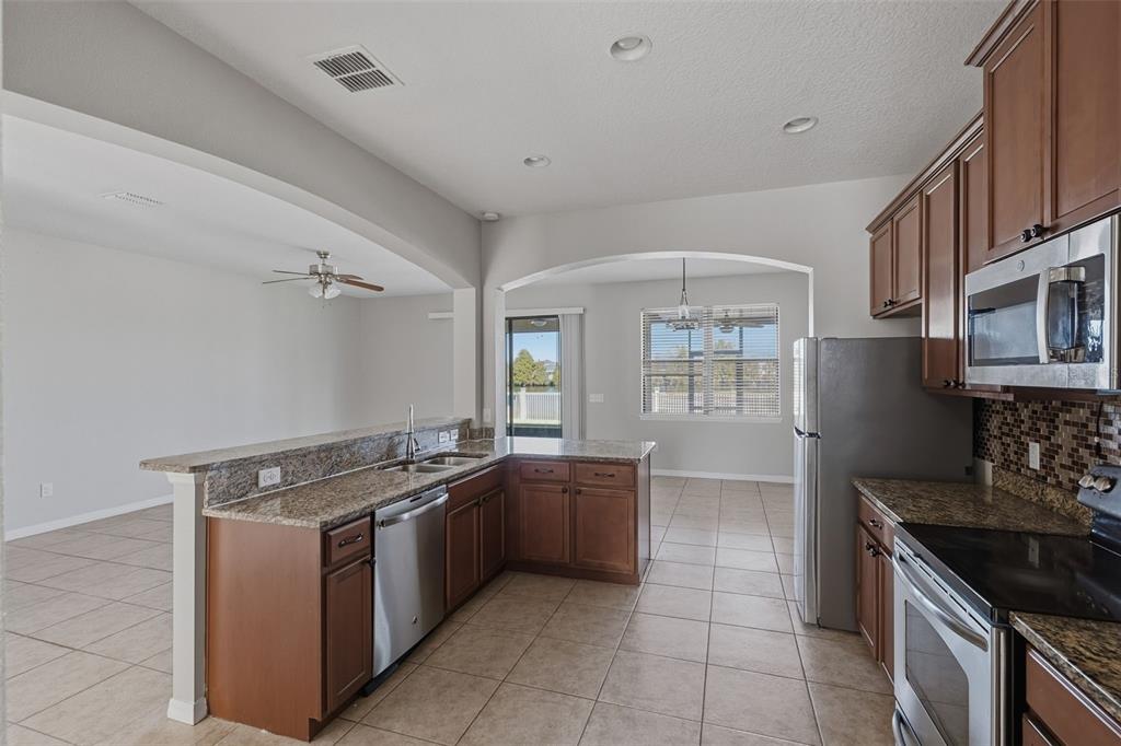 2318 Sebago Drive Lakeland, FL 33805 - Photo 9 of 54 a kitchen with stainless steel appliances granite countertop a stove and a sink