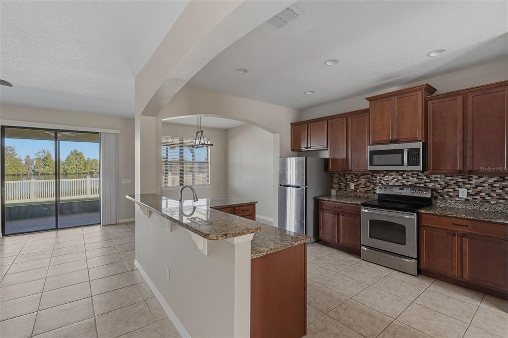 2318 Sebago Drive Lakeland, FL 33805 - Photo 10 of 54 a kitchen with stainless steel appliances granite countertop a stove and a sink