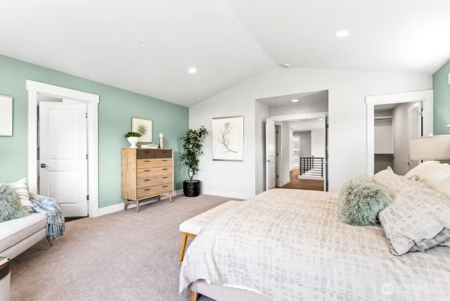 a spacious bedroom with a bed a couch and a view of living room