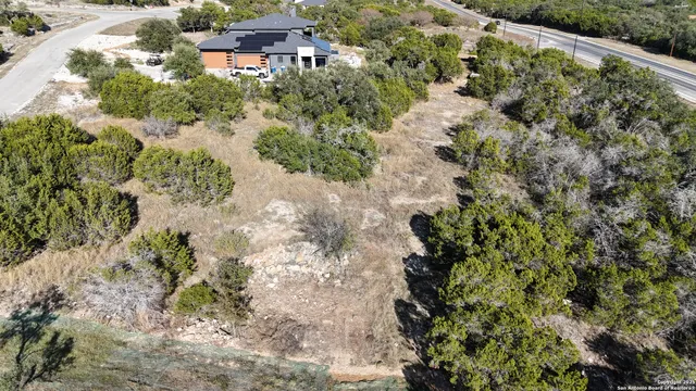 an aerial view of residential house with outdoor space and trees all around