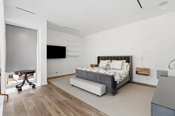 a spacious bedroom with a bed and a flat screen tv