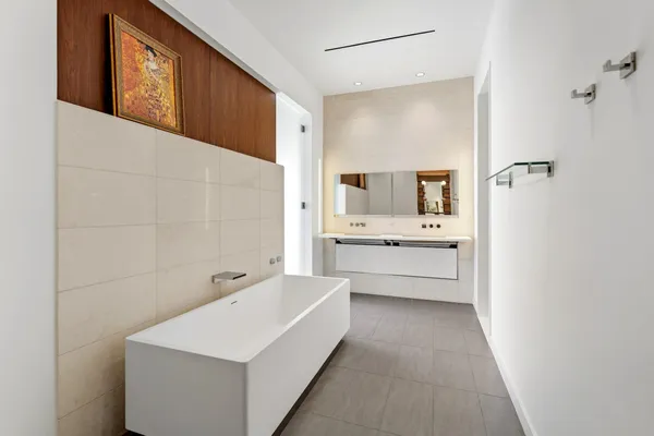 a bathroom with a double vanity sink a mirror and a bathtub