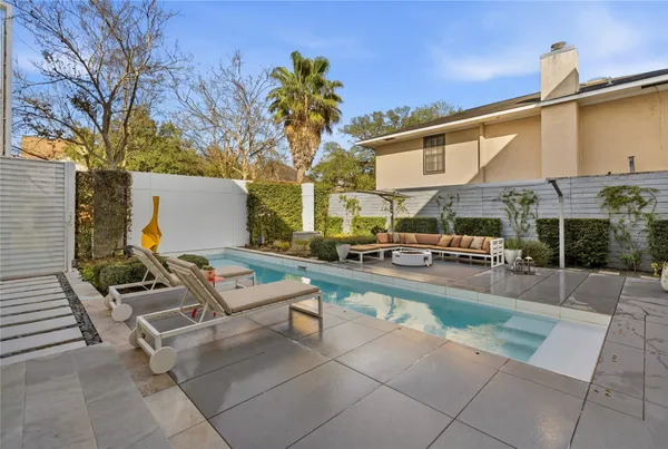 a view of a patio with couches and table and chairs with wooden floor and fence