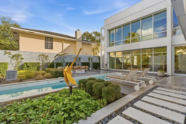 a view of a house with backyard sitting area and swimming pool