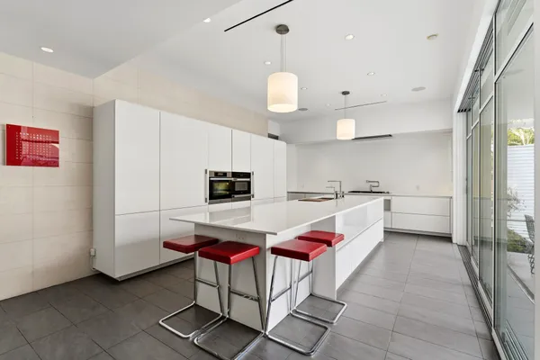a kitchen with stainless steel appliances kitchen island granite countertop a sink and a refrigerator