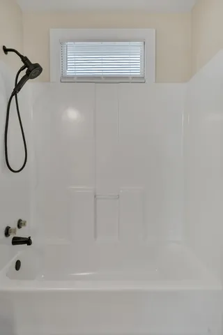 a bathroom with a bath tub with a shower