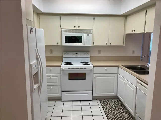 a kitchen with white cabinets and white appliances