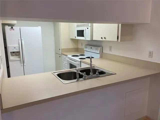 a kitchen with stainless steel appliances a stove a sink and a refrigerator