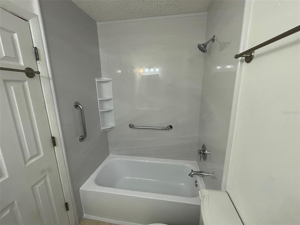 9000 Griggs Road, Unit C Englewood, FL 34224 - Photo 7 of 10 a bathroom with a bathtub
