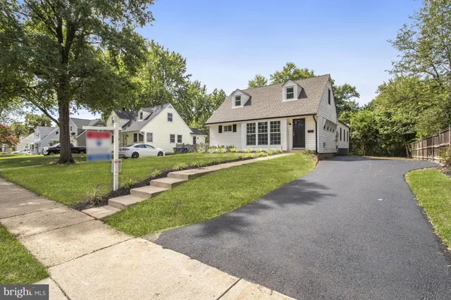 a front view of a house with a yard and trees