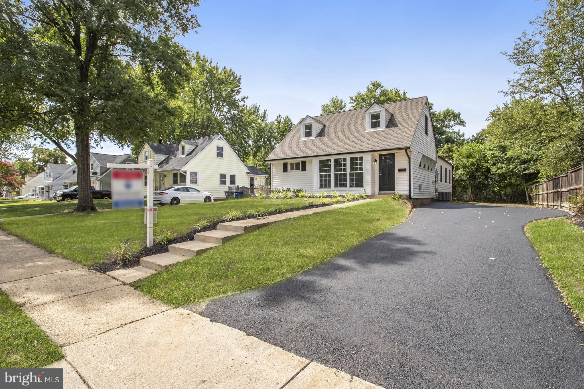 a front view of a house with a yard and trees