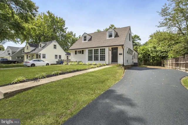 a front view of a house with a yard and trees