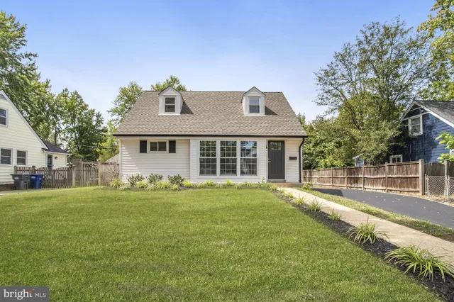 a front view of a house with a yard and trees