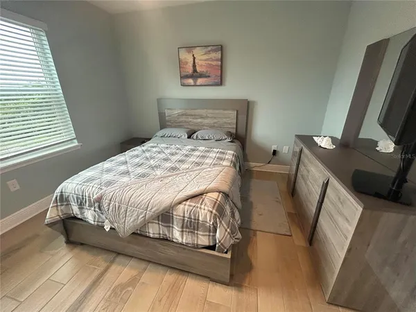 a bedroom with a bed and a flat screen tv