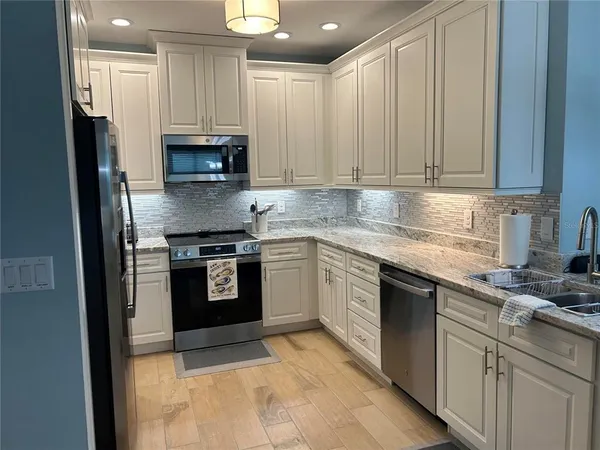 a kitchen with stainless steel appliances granite countertop a stove top oven a sink and dishwasher