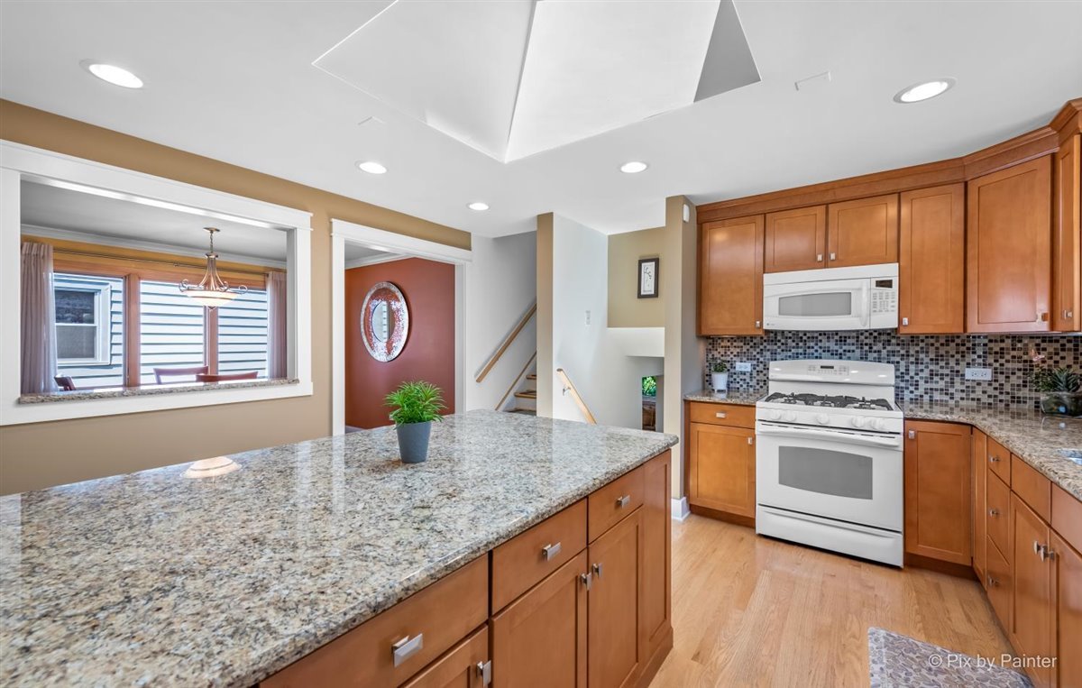1111 South Finley Road Lombard, IL 60148 - Photo 8 of 30 a kitchen with stainless steel appliances granite countertop a sink a stove and wooden floors