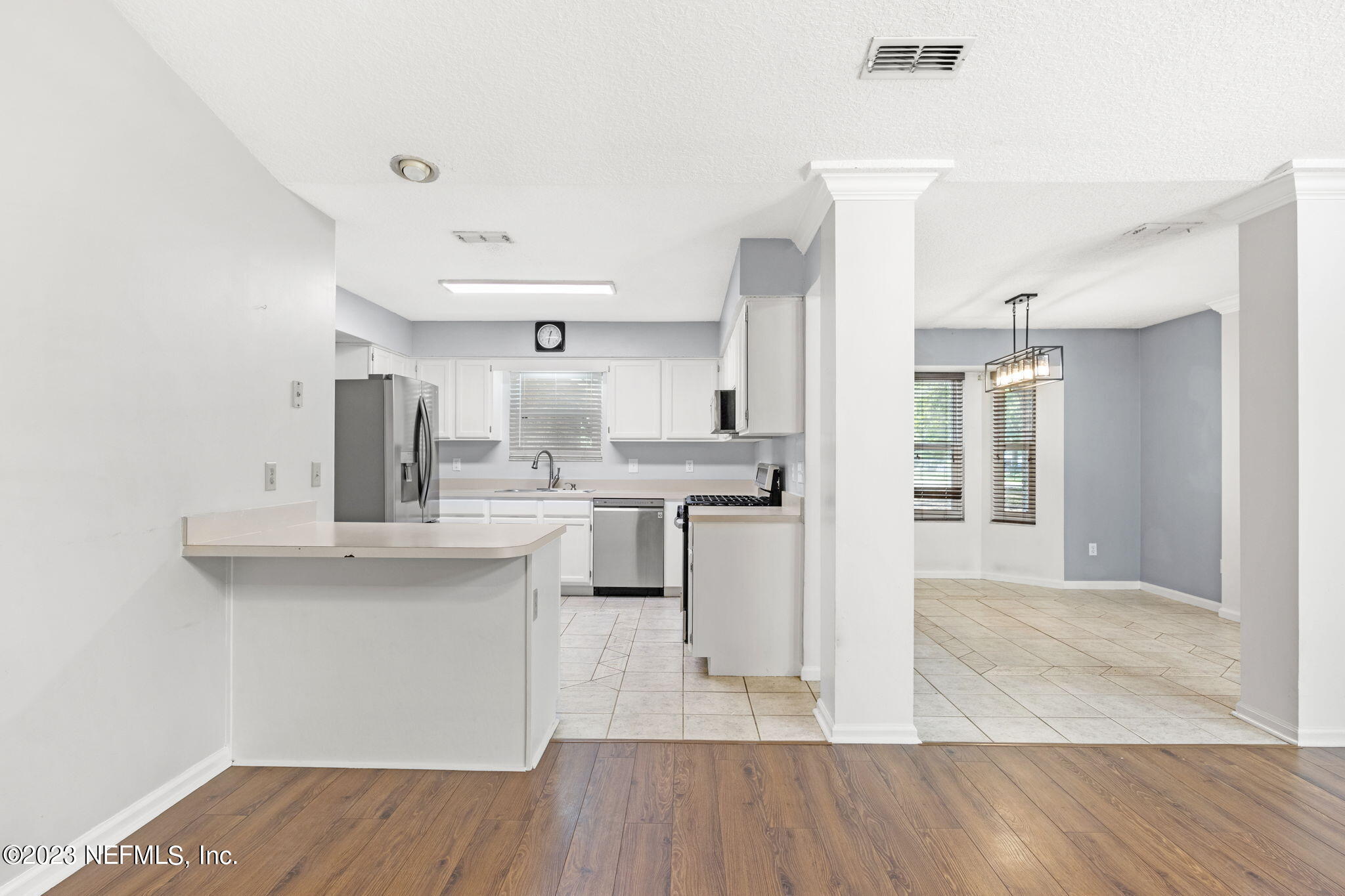 3233 Fritz Road Jacksonville, FL 32226 - Photo 15 of 43 a kitchen with kitchen island a sink cabinets and wooden floor