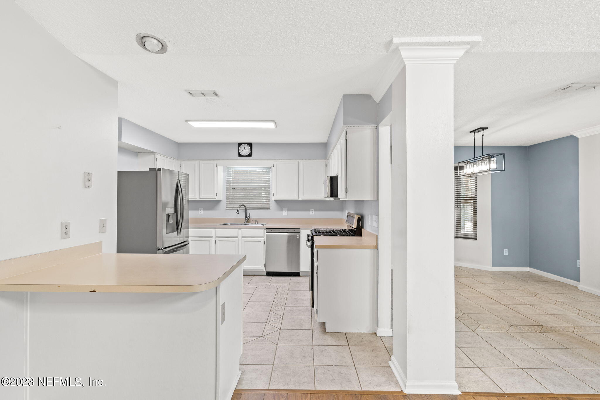 3233 Fritz Road Jacksonville, FL 32226 - Photo 16 of 43 a kitchen with granite countertop a refrigerator and cabinets