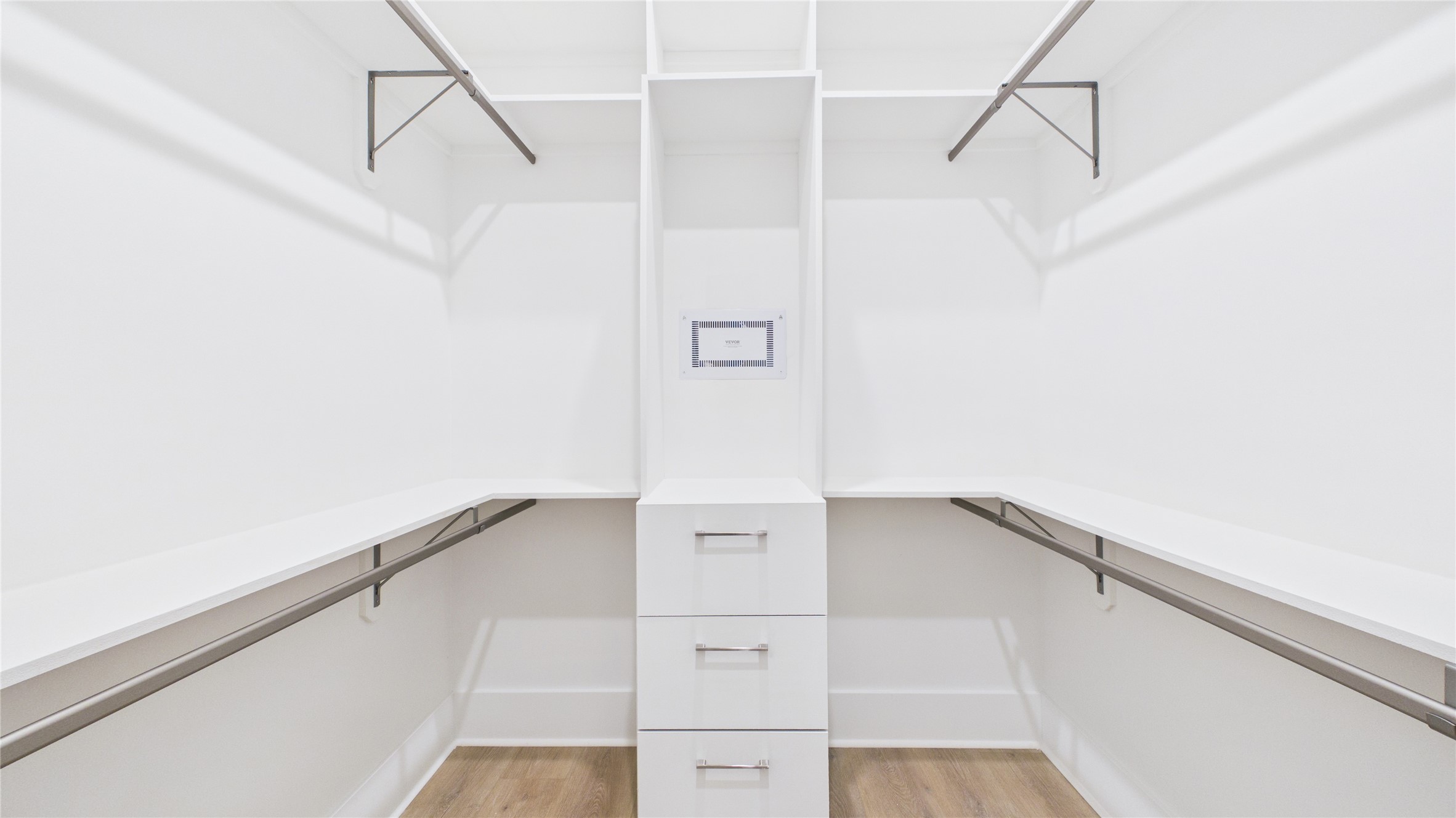 602 Skyland Terrace Way Houston, TX 77009 - Photo 32 of 40 This image shows a spacious walk-in closet with white shelving, multiple hanging rods, and built-in drawers, offering ample storage space and modern design.