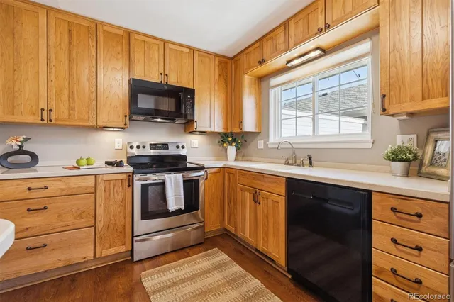 a kitchen with granite countertop cabinets stainless steel appliances and a window