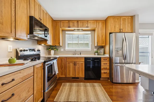 a kitchen with stainless steel appliances granite countertop a refrigerator sink and stove
