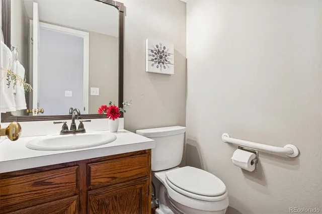 a bathroom with a sink vanity mirror and toilet