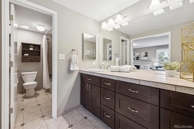 a bathroom with a sink a toilet and a mirror